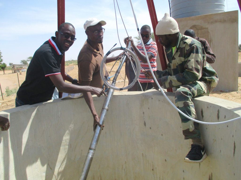 Volunteers install the solar powered pumping system Volunteers install the solar powered pumping system