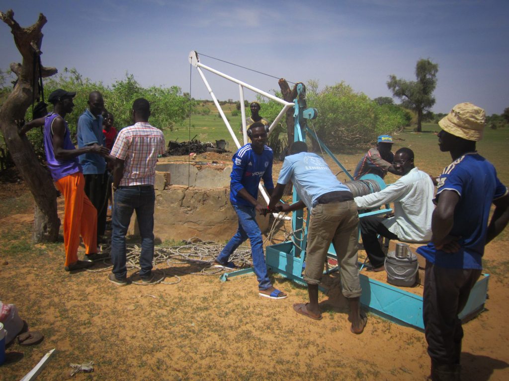 Well rehabilitation: volunteers operate the locally-built winch system Well rehabilitation: volunteers operate the locally-built winch system