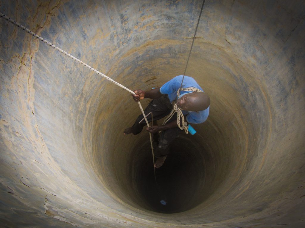 Well rehabilitation: Volunteers are lowered down into the well to clean out the debris Well rehabilitation: Volunteers are lowered down into the well to clean out the debris